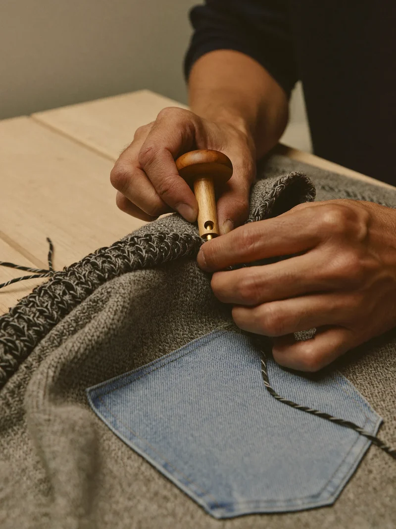 Illustration: Stopfen eines Strickpullovers mit Stopfpilz und kontrastierendem Wollgarn